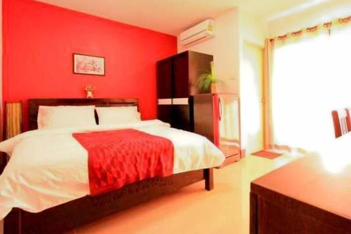 A bedroom with a bed, a nightstand, a dresser, and a window with curtains.