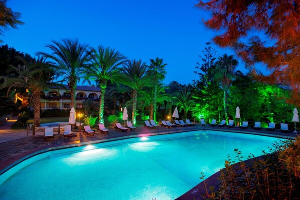 Alberca al aire libre, sombrillas en la alberca y camastros 