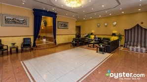 Een hotel lobby met een kroonluchter, een zithoek en een receptiebalie.