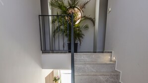 A staircase with a modern design, featuring a metal railing and a potted plant at the top. - Eng Group Hotels (Bodrum)