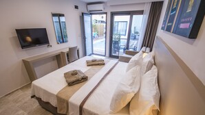 A hotel room with a bed, a flat-screen TV mounted on the wall, a window, and a door leading to a balcony. - Eng Group Hotels (Bodrum)
