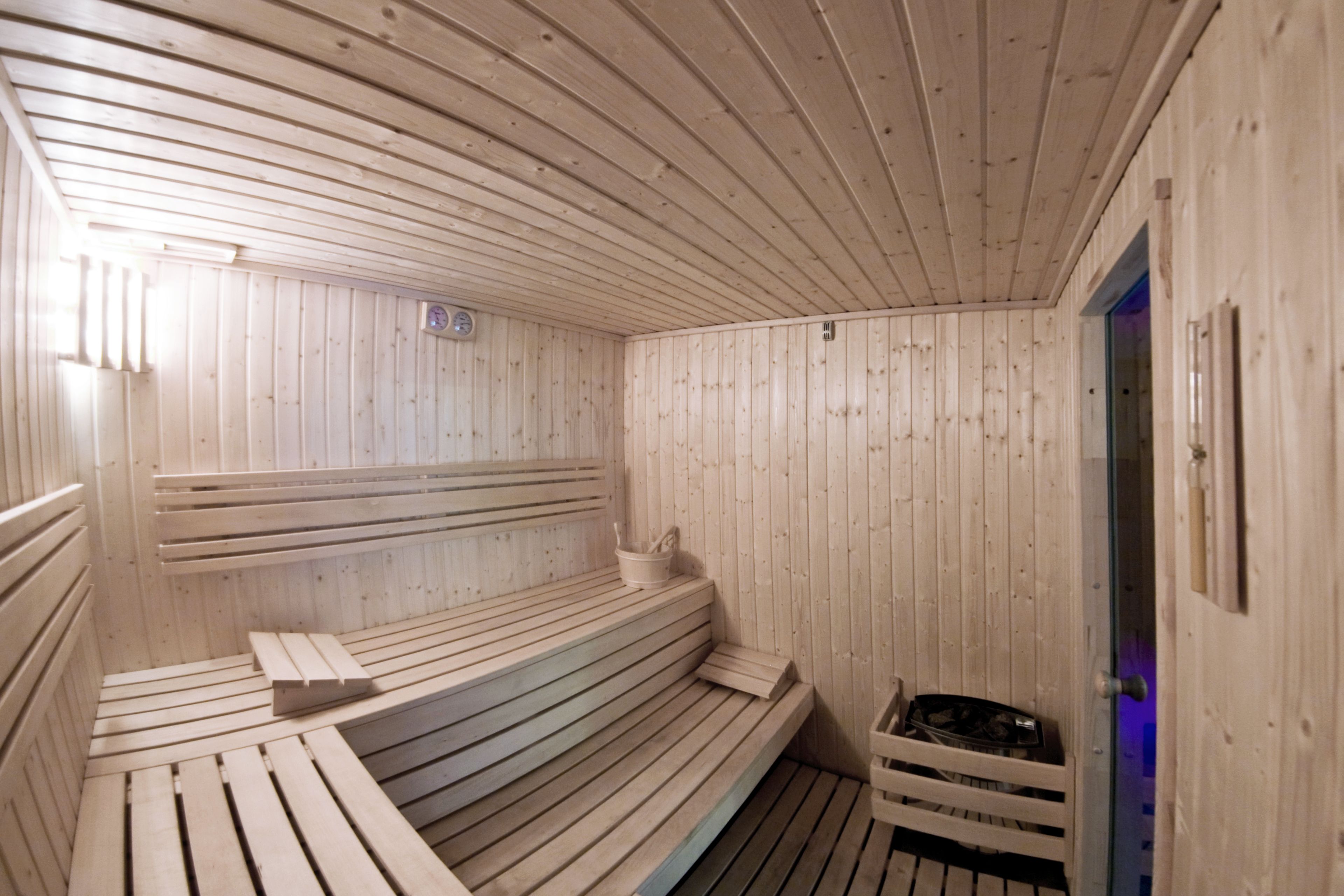 Una sauna con bancos de madera y la puerta de un baño de vapor.