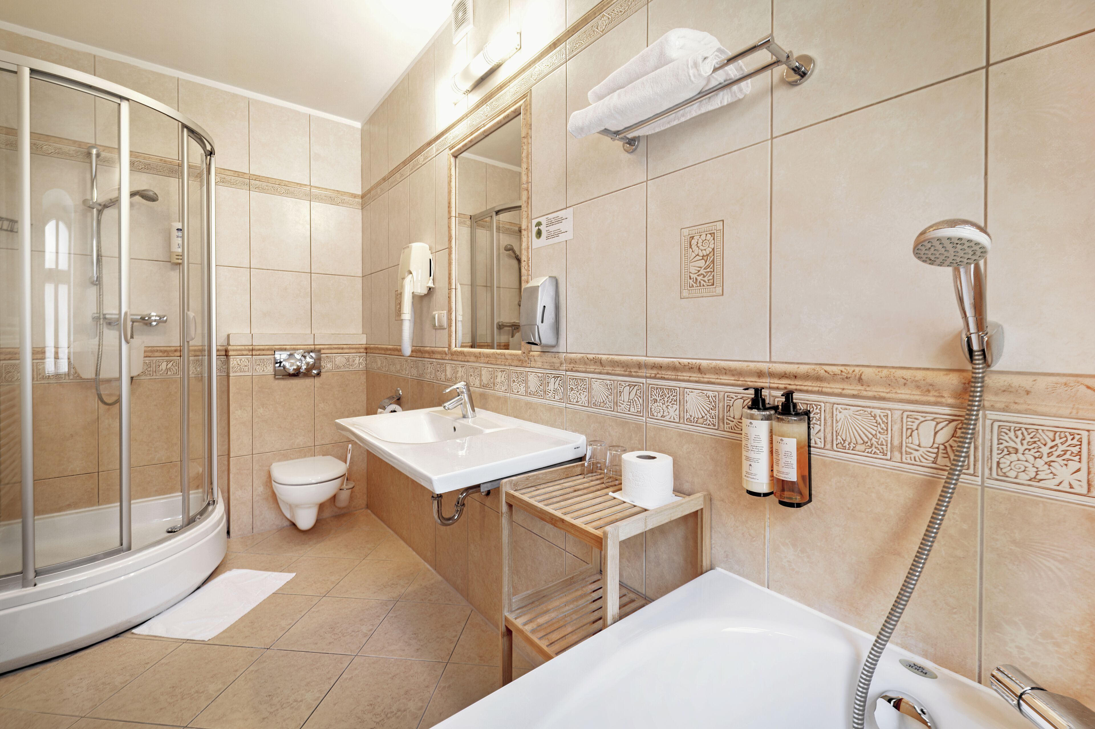 Une salle de bain moderne avec une douche à parois de verre, un lavabo, des toilettes et une baignoire.