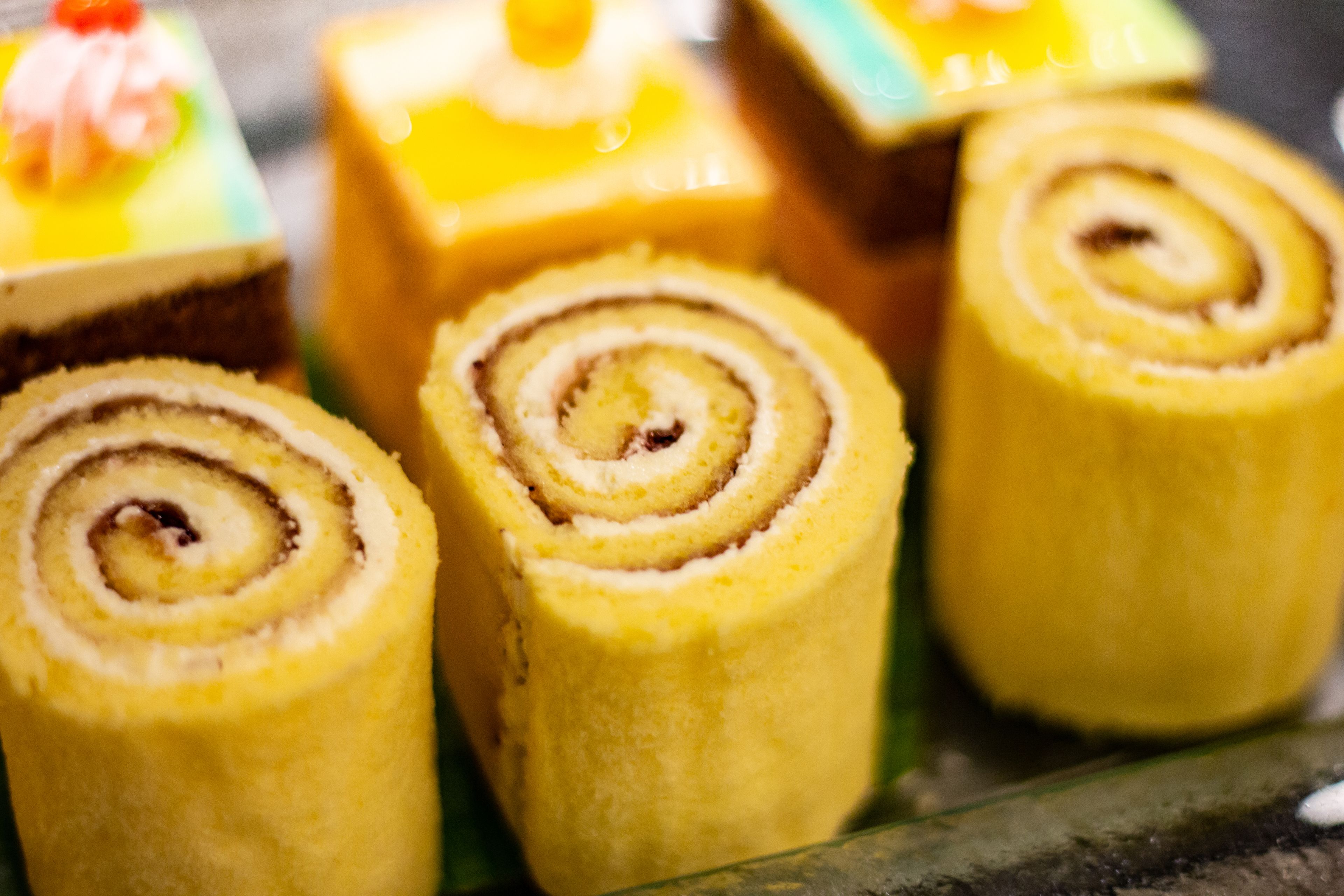 Close-up de vários pastéis enrolados com padrões espirais visíveis, provavelmente um tipo de pão doce.