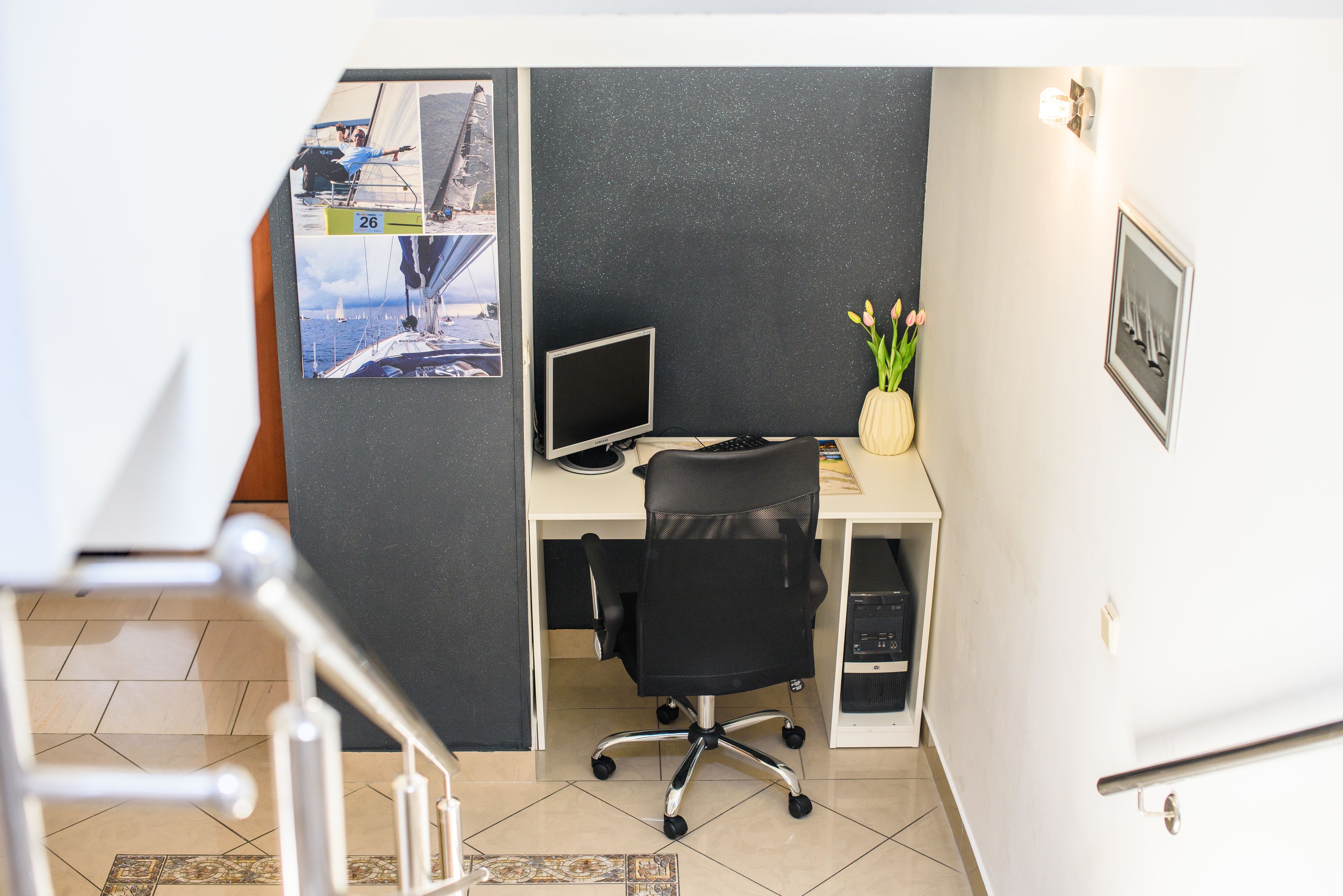 A modern office space with a desk, computer, and a framed picture on the wall.