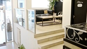Een modern interieur met een trap naar een woonruimte, met een leren bank, een salontafel en een potplant.