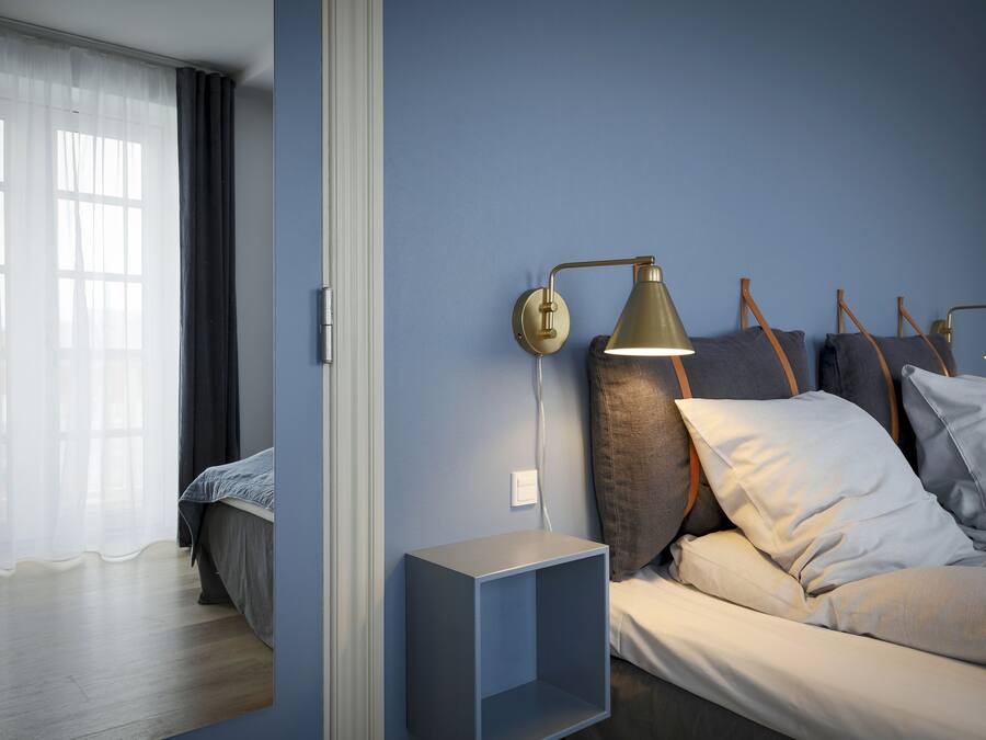 Un dormitorio moderno con cama, lámparas de noche y mesita de noche.