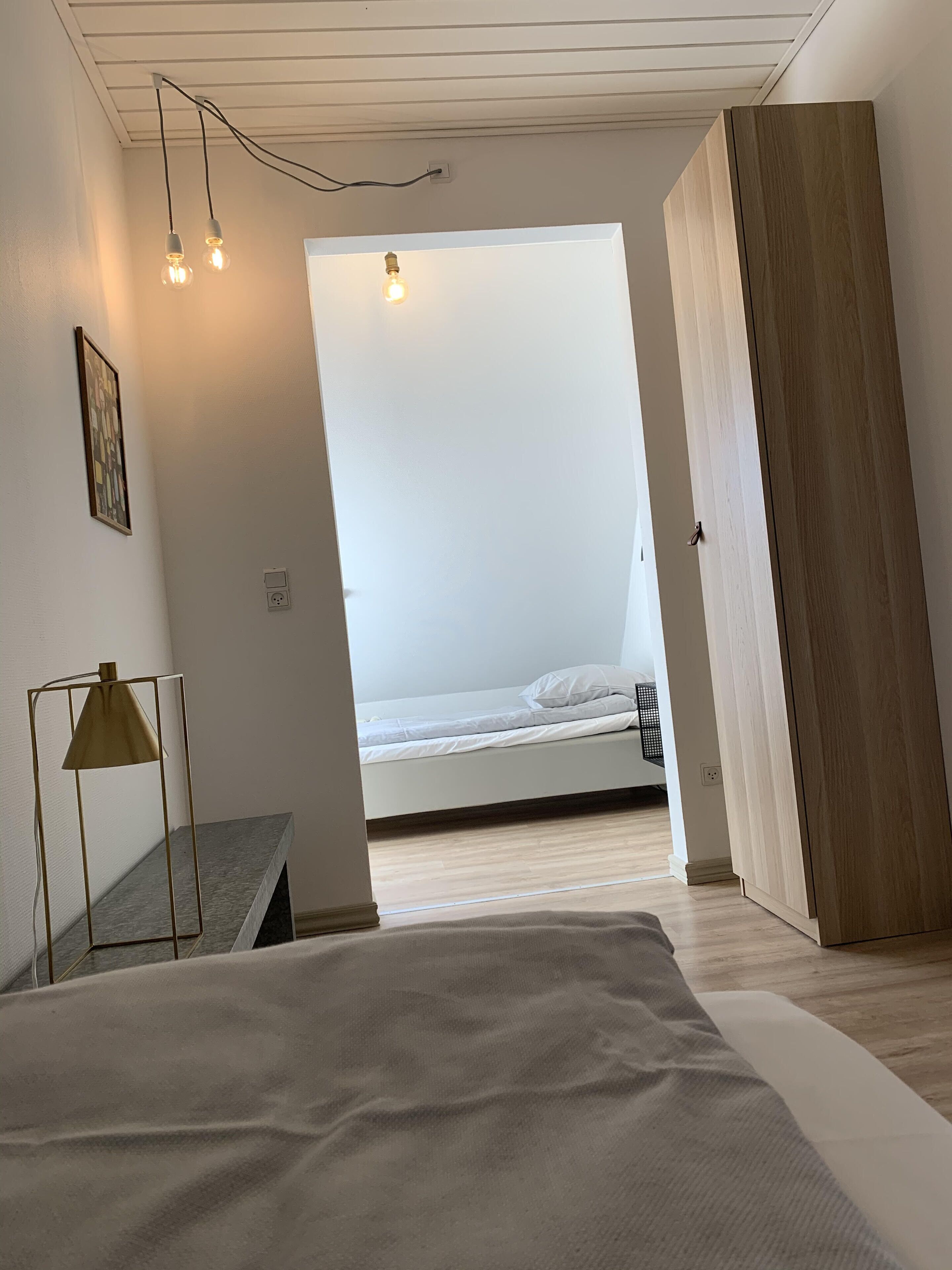Une chambre à coucher moderne avec un lit, un bureau et une armoire.