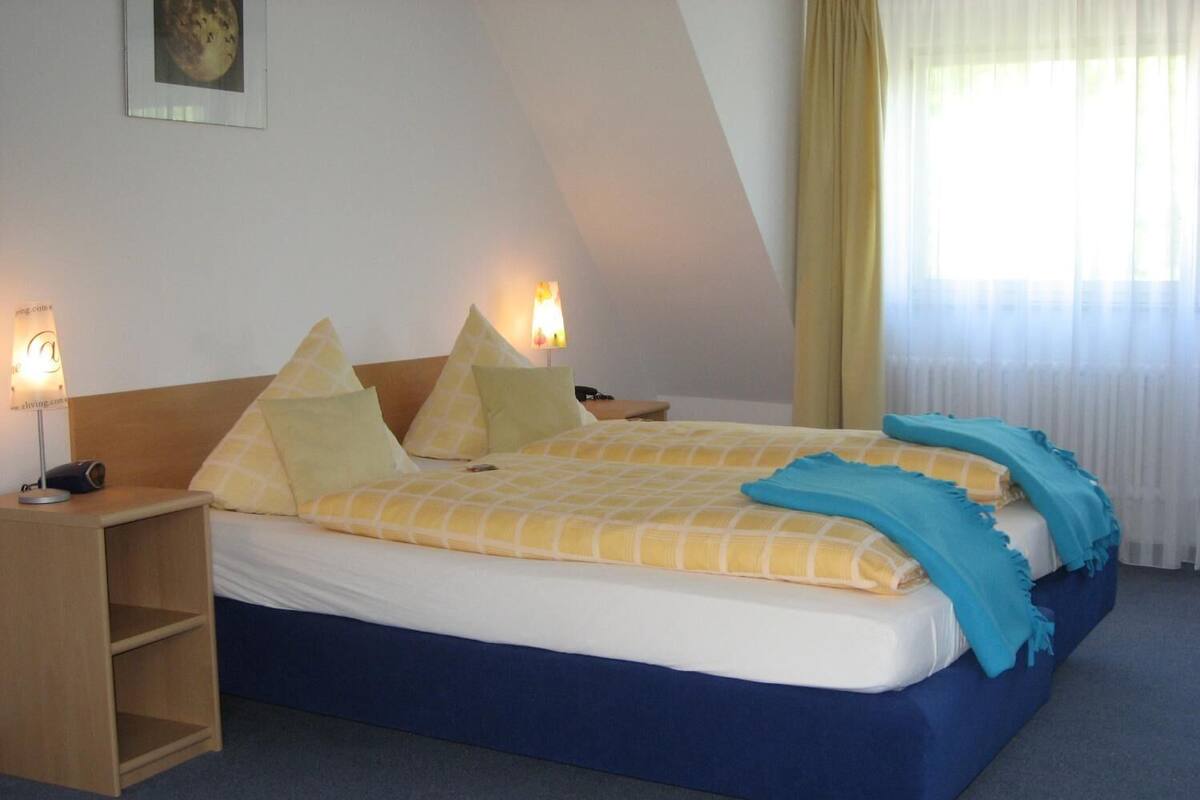 A bedroom with a bed, bedside tables, and a nightstand.