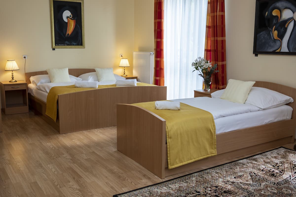 Driepersoonskamer | Bedden met traagschuimmatras, een kluis op de kamer, een bureau