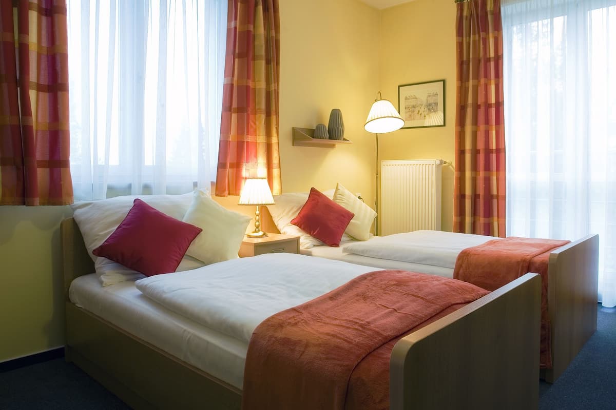 Twin kamer | Bedden met traagschuimmatras, een kluis op de kamer, een bureau