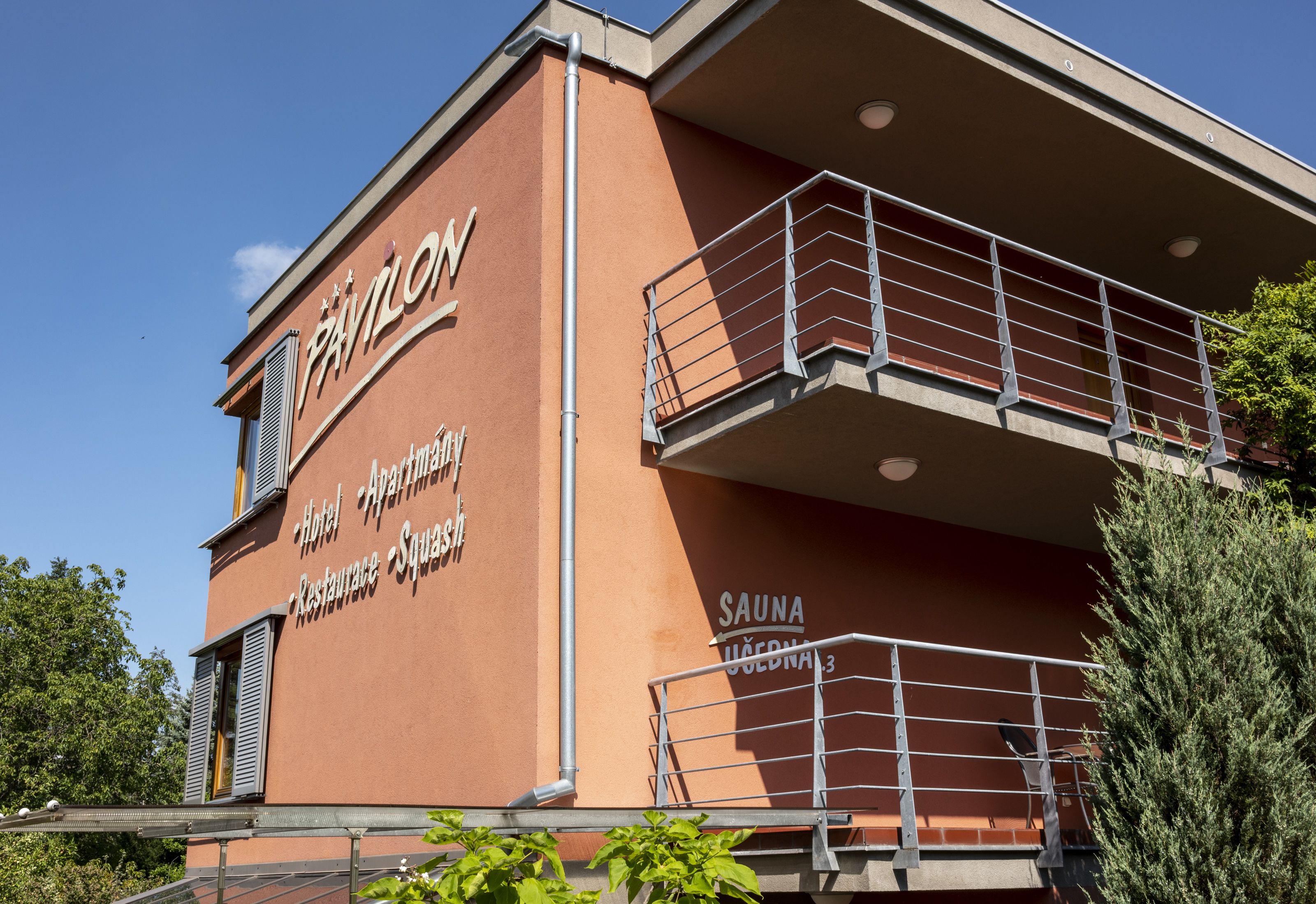 Een gebouw met een bord waarop staat: Pavlov Hotel, Appartement, Restaurant, Sauna.