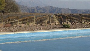 A pool with a view of mountains in the background. - Chañarmuyo Hotel de Vino (Famatina)