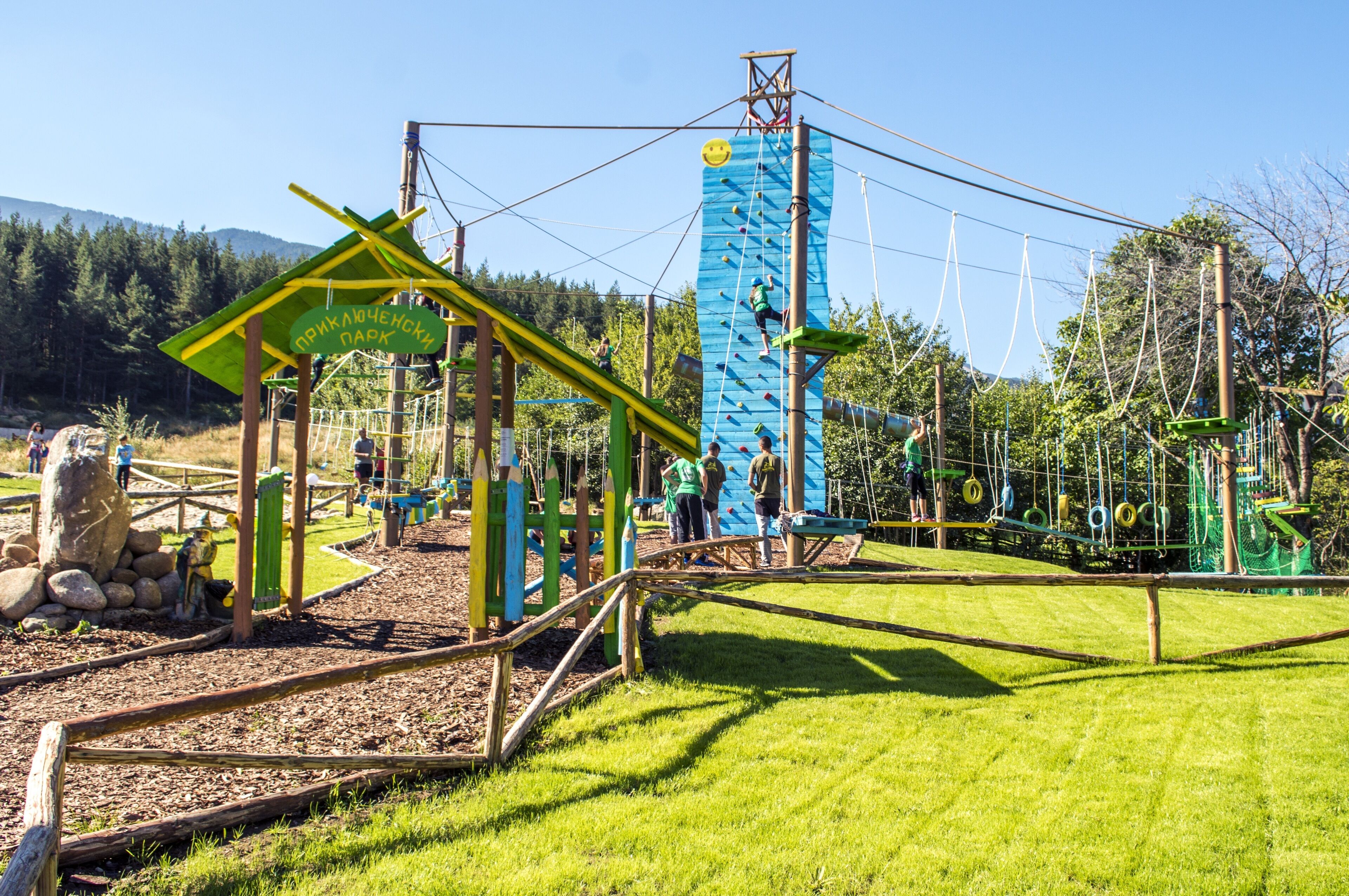 An outdoor adventure park with climbing structures and a wooden play area.
