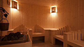 Una sauna con bancos de madera, un cubo y un montón de piedras.