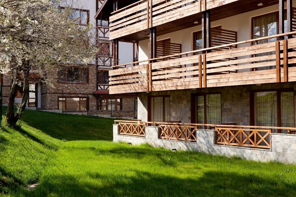 A multi-story building with wooden balconies and stone walls.