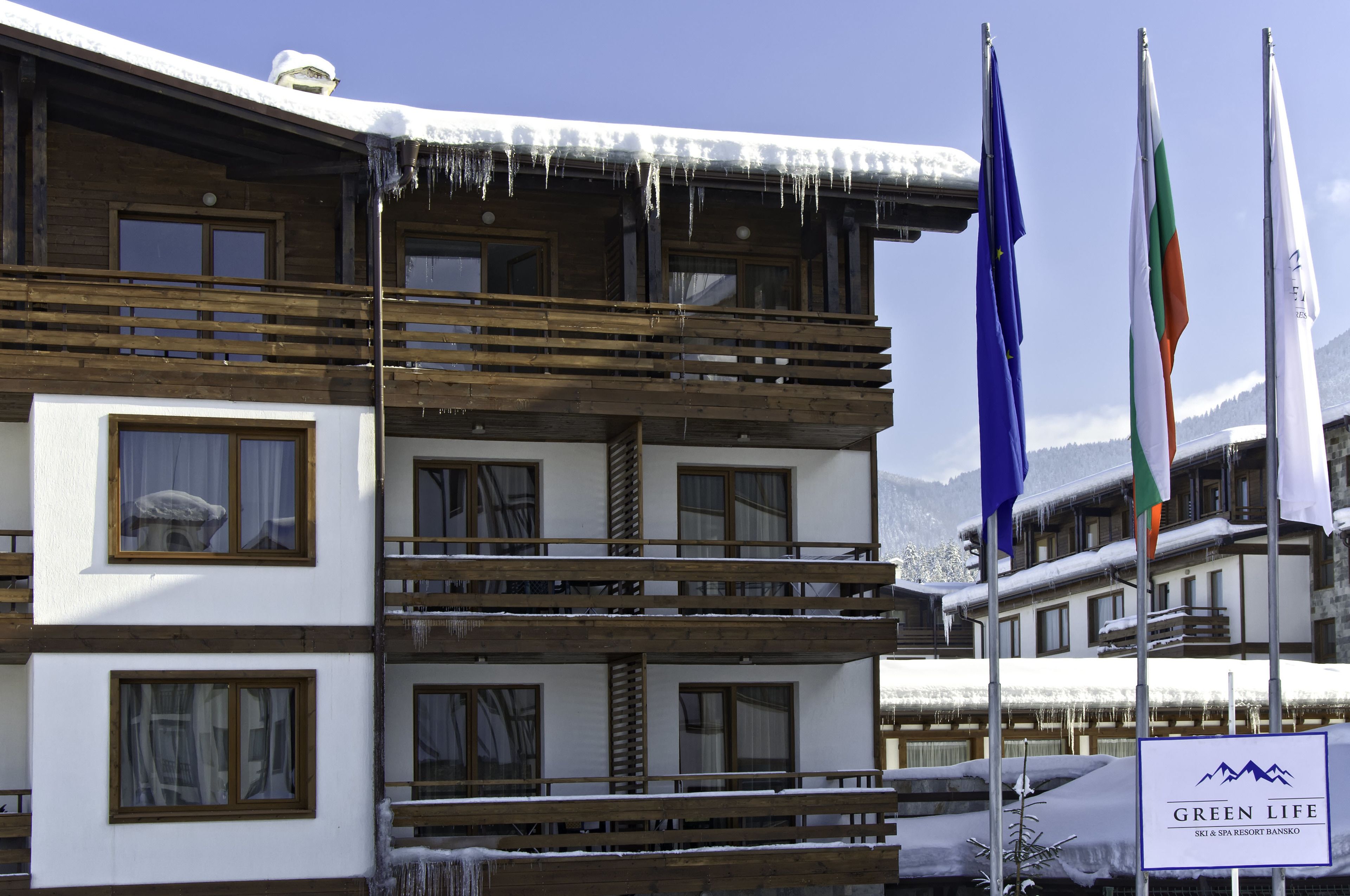 Een meerlaags gebouw met houten balkons en sneeuw bedekte daken.