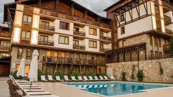 A hotel with a pool area, multiple balconies, and outdoor seating.