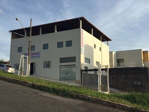 Un edificio de dos pisos con un cartel que indica 'Pousada', señalando que es un alojamiento.
