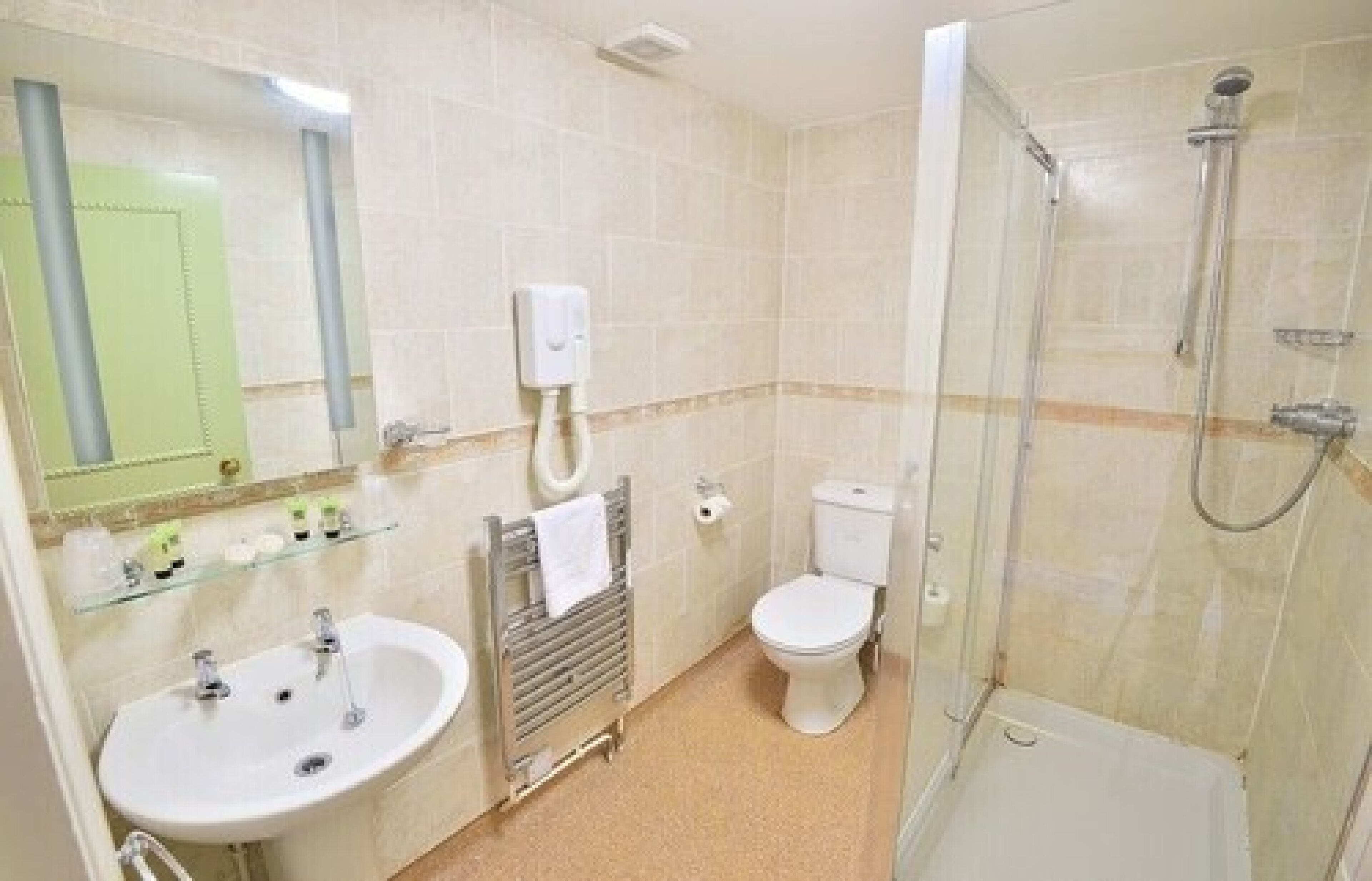 A bathroom with a sink, toilet, and shower.