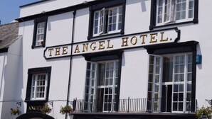 A building with a sign reading "The Angel Hotel." It features a white facade with black trim, multiple windows, and a balcony with railings. - The Angel Hotel (Coleford)