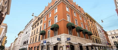 A hotel with multiple floors, a classic architectural style, and a prominent entrance with a sign.