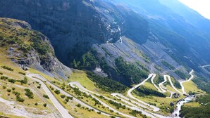 Una carretera de montaña serpenteante con un valle abajo.