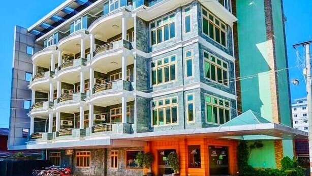 A multi-story hotel with balconies, large windows, and a modern architectural design. - Shwe Kyun Hotel (Taunggyi)