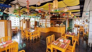 A restaurant with wooden furniture, a bar area, and hanging decorations. - Shwe Kyun Hotel (Taunggyi)