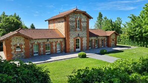 Un bâtiment historique doté d’une tour centrale, de nombreuses fenêtres et d’une cour dallée.