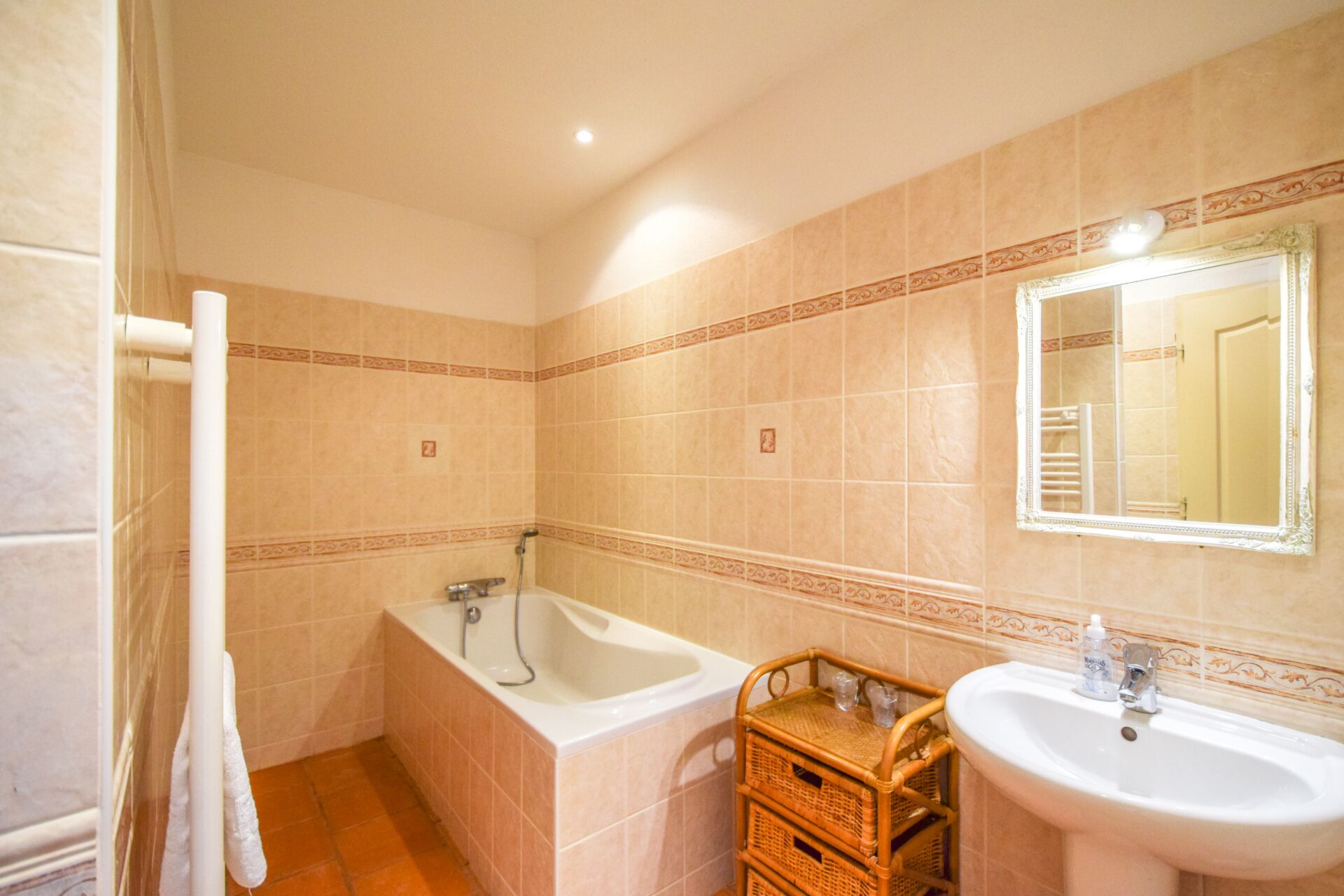 Un bagno con una vasca, un lavandino e uno specchio.