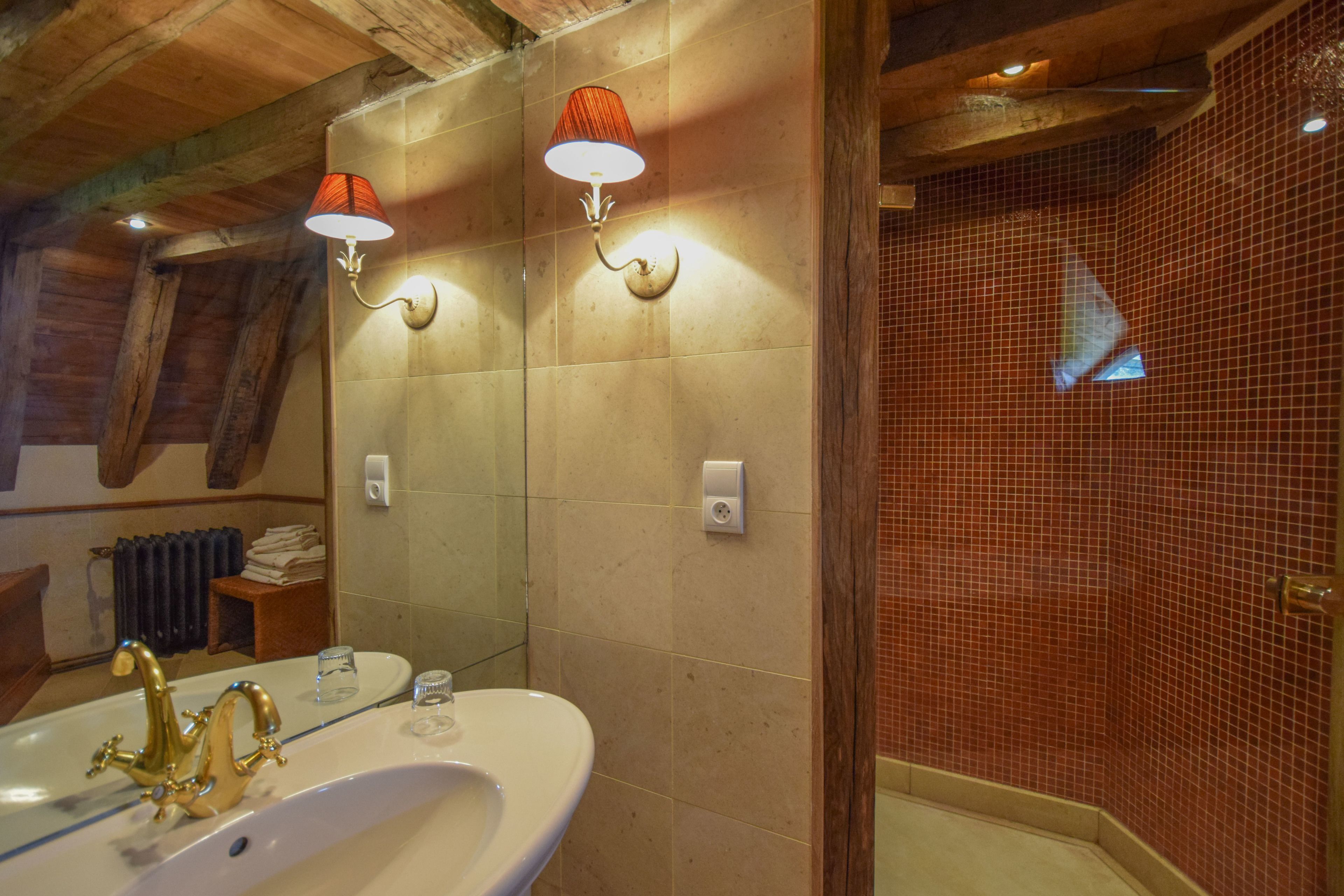 Un baño con lavamanos blanco, toallero y espejo.