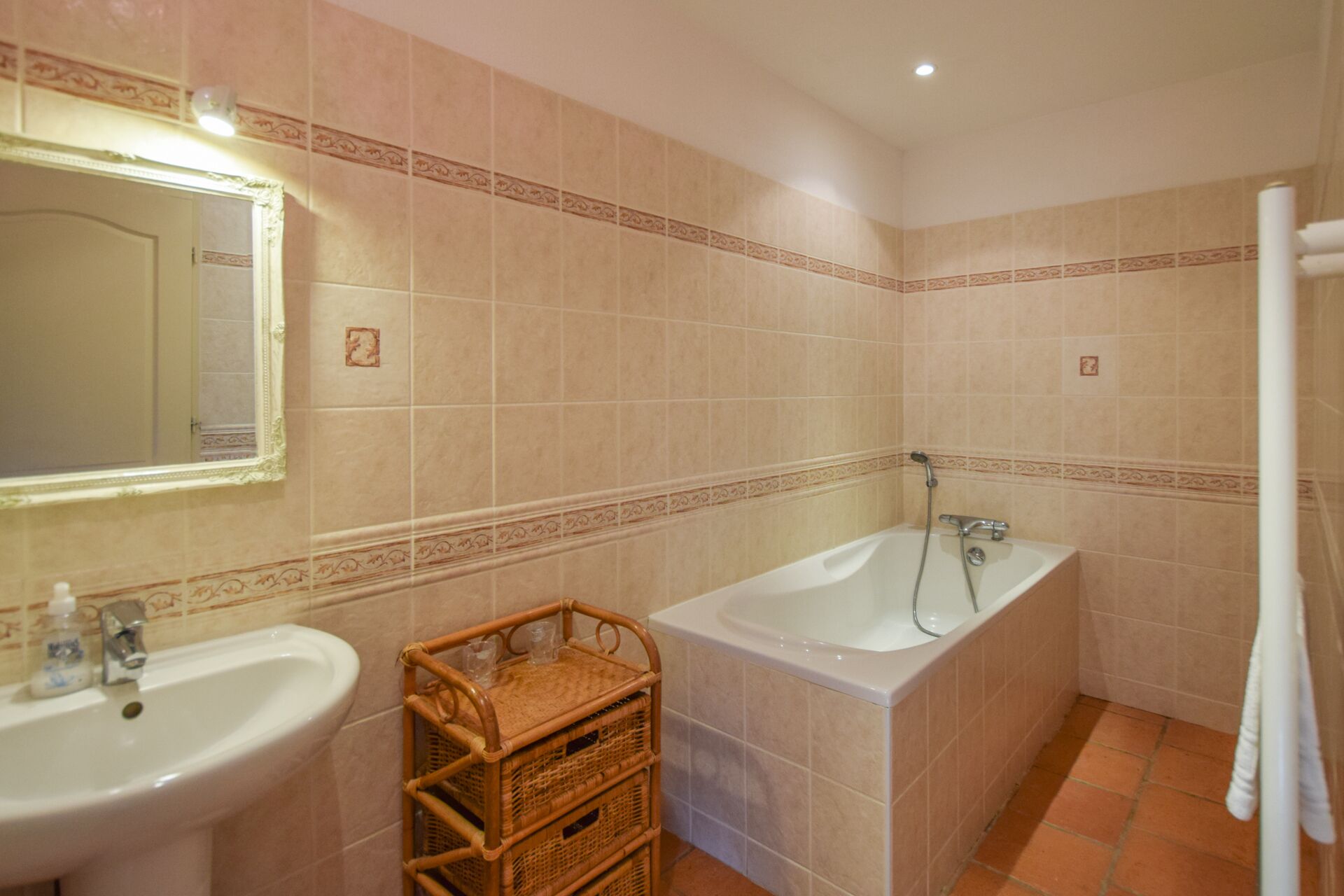 A bathroom with a sink, a mirror, a bathtub, and a shower.
