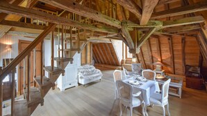 Ein rustikales Holzinterieur mit Schlafzimmer im oberen Bereich, Essbereich und Treppe.