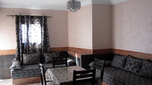 Un comedor con una mesa y sillas, un sofá y una araña.