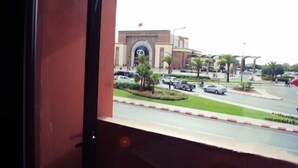 Vista de un edificio con un gran arco y palmeras al frente.