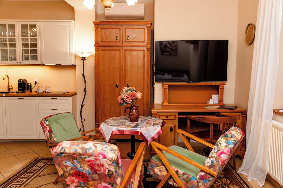 A cozy living room with a dining area, a TV, and a kitchen in the background.