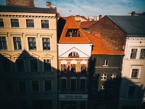 Una hilera de edificios de varios pisos con estilos arquitectónicos diversos, incluyendo un edificio con techo de tejas rojas y otro con fachada blanca.