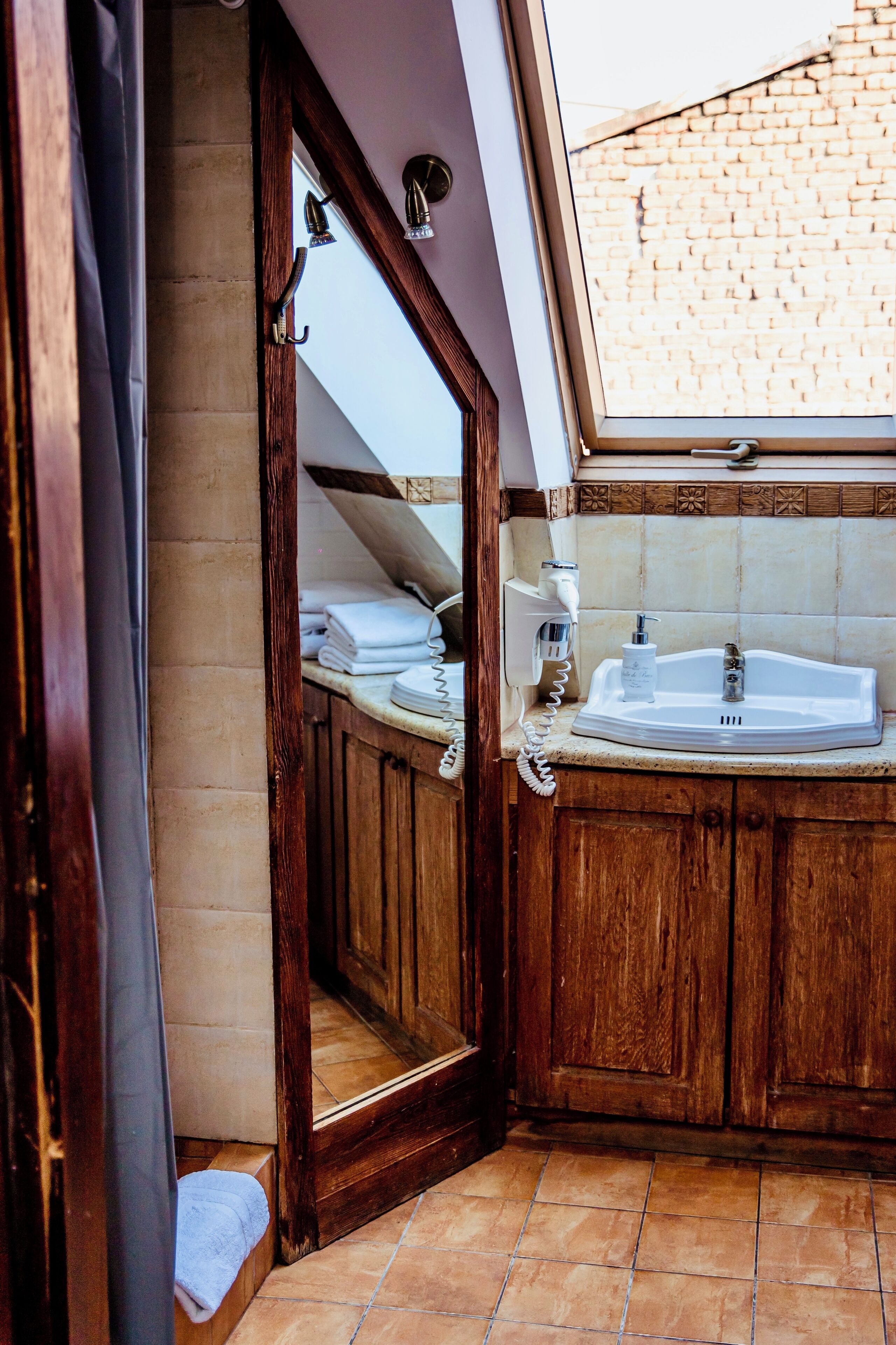 Une salle de bain avec un meuble-lavabo en bois, un évier et un miroir.