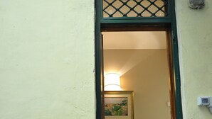 A staircase with a handrail, a doormat, and a framed picture on the wall. - Angel Spagna Suite (Rome)