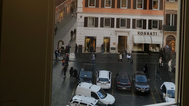 A view of a street with buildings, including a Rossati store, and parked cars. - Angel Spagna Suite (Rome)