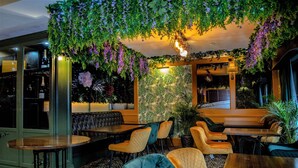 A restaurant with a green interior, wooden tables, and chairs. - OYO The Townhouse (Durham)