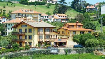 A rural mountain village with traditional architecture, including multi-story buildings with balconies and terracotta roofs.
