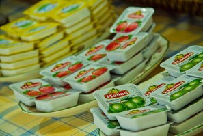 A display of Helios brand yogurt in strawberry and green apple flavors.