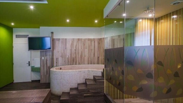 Un baño moderno con una bañera curva, cabina de ducha de vidrio y tocador de madera.