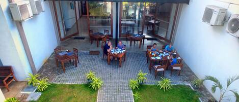 A courtyard with outdoor seating, air conditioning units, and potted plants.