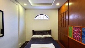 Un dormitorio con cama, ventana y pared de paneles de madera.