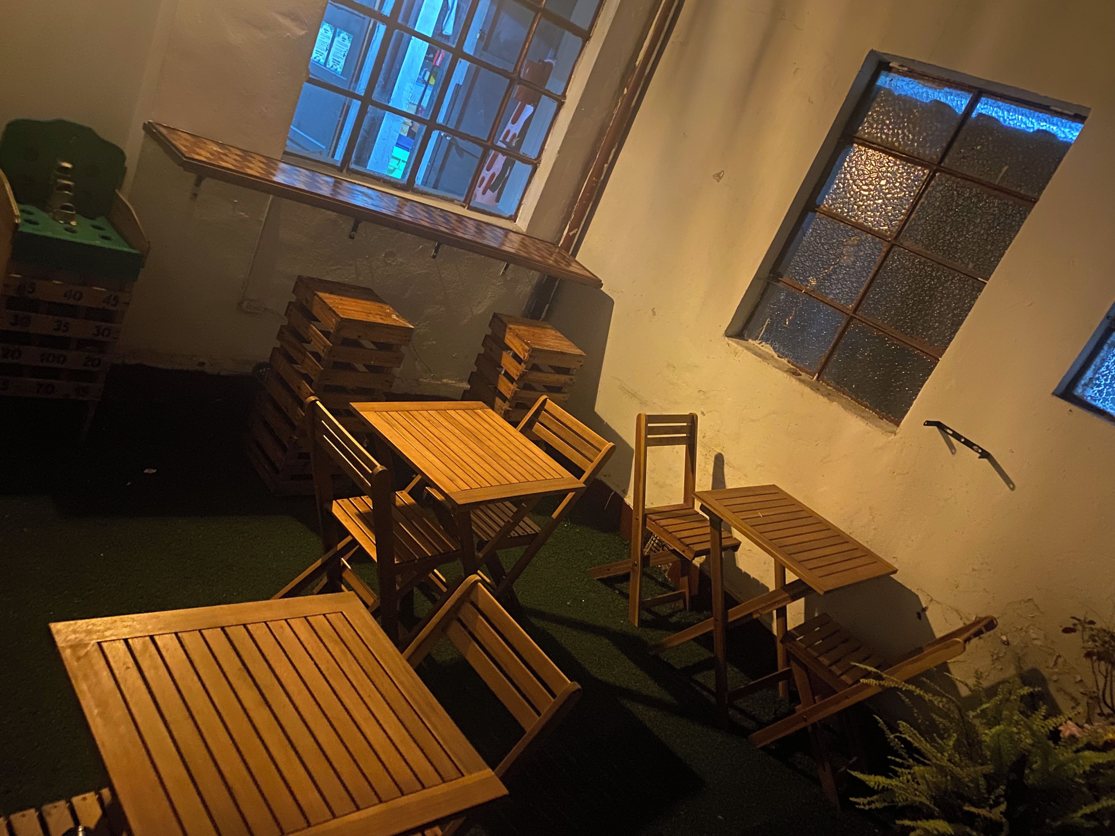 Quarto com mobiliário de madeira, incluindo mesas e cadeiras, e janela com vista.