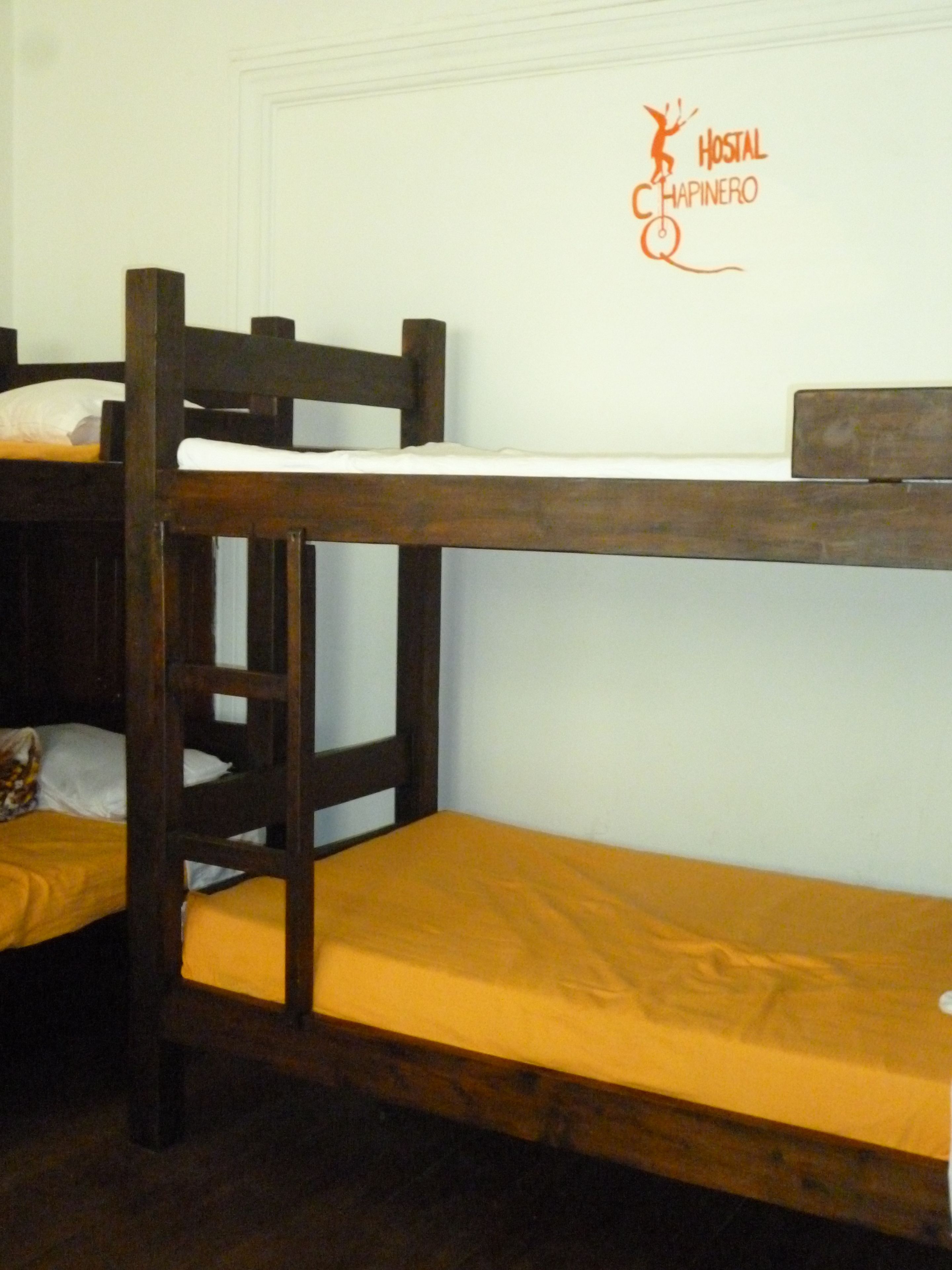A bunk bed with a wooden frame and yellow bedding.