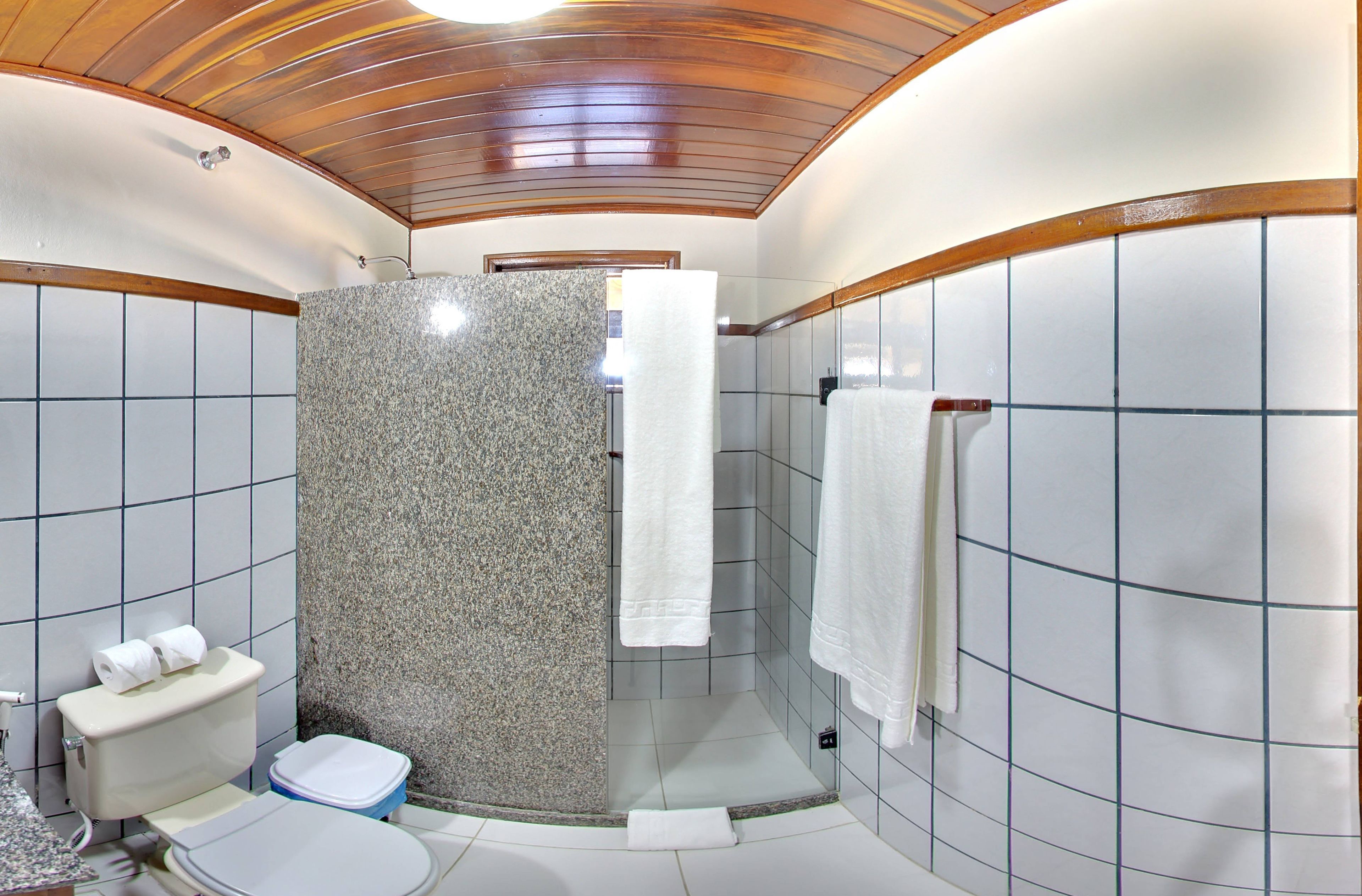A bathroom with a shower, toilet, and sink.
